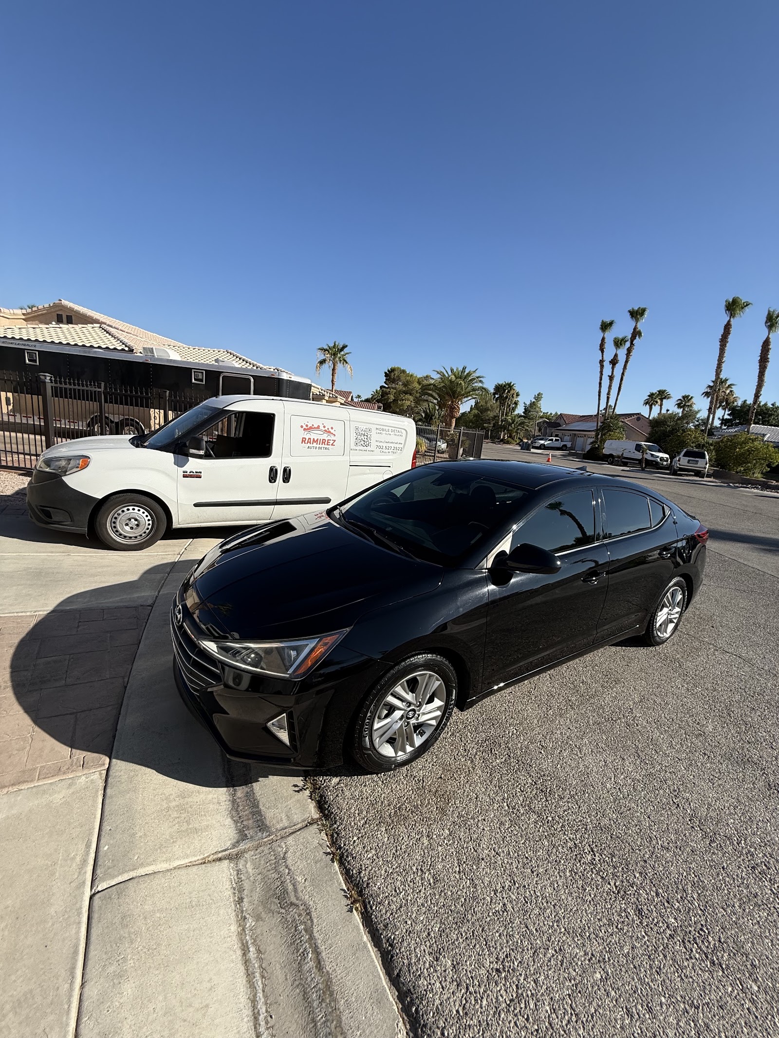 Detailed black Hyundai Elantra with Ramirez Auto Detail mobile van in background